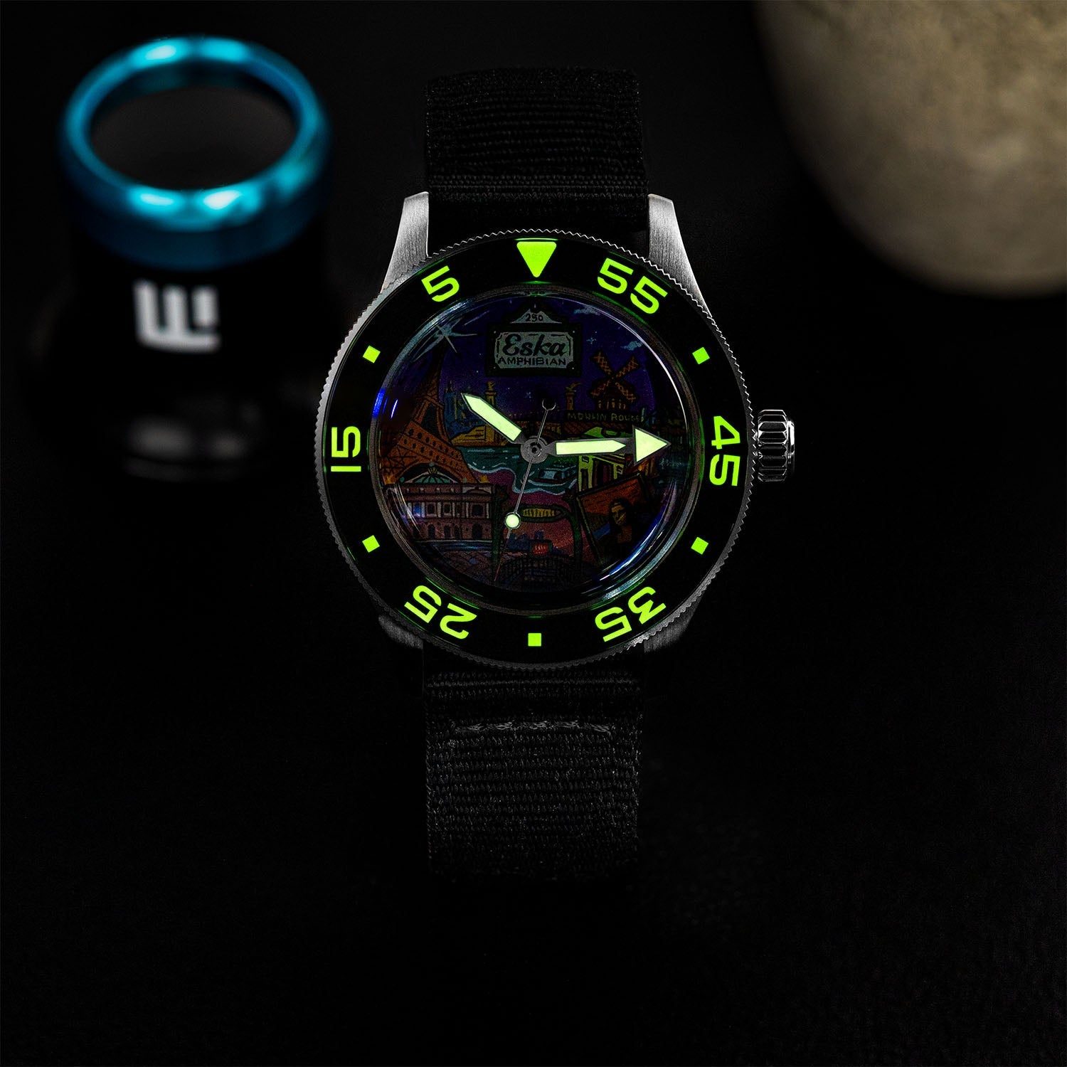 ESKA Amphibian Cœur de Paris — Lume shot in the dark, the dial markers glowing above the hand-painted Parisian cityscape on a 40mm steel diver, customized limited edition by IFL Watches.