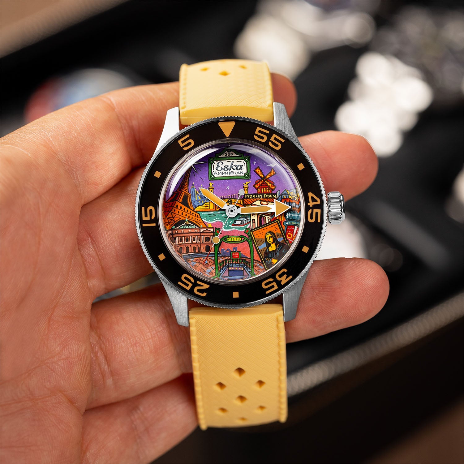 ESKA Amphibian Cœur de Paris — Held in hand on its sand Tropic strap, showing the hand-painted city dial and black dive bezel, limited edition timepiece by IFL Watches.