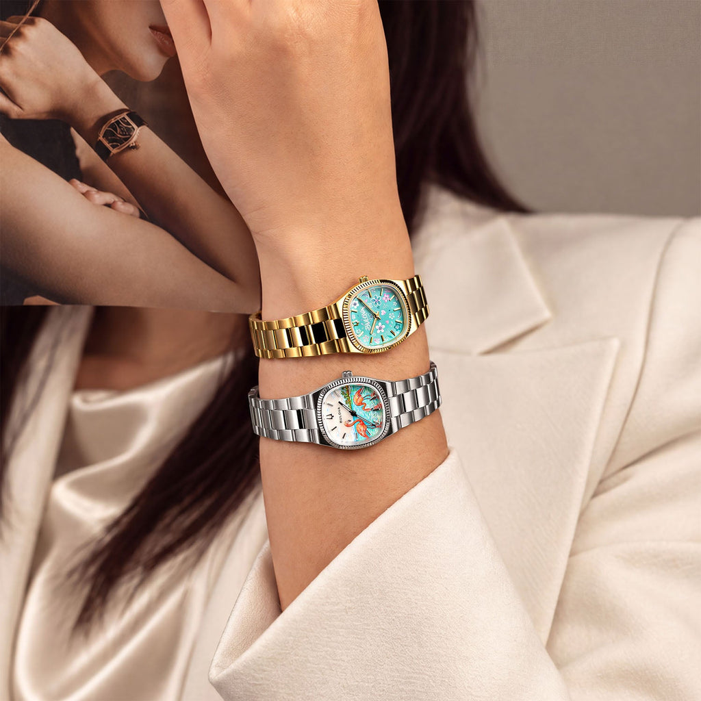 Bulova Super Seville Jardin Bleu — Raised wrist against a cream blazer, the hand-painted turquoise floral dial and gold-tone bracelet stacked above a silver companion watch, a bespoke timepiece by IFL Watches.