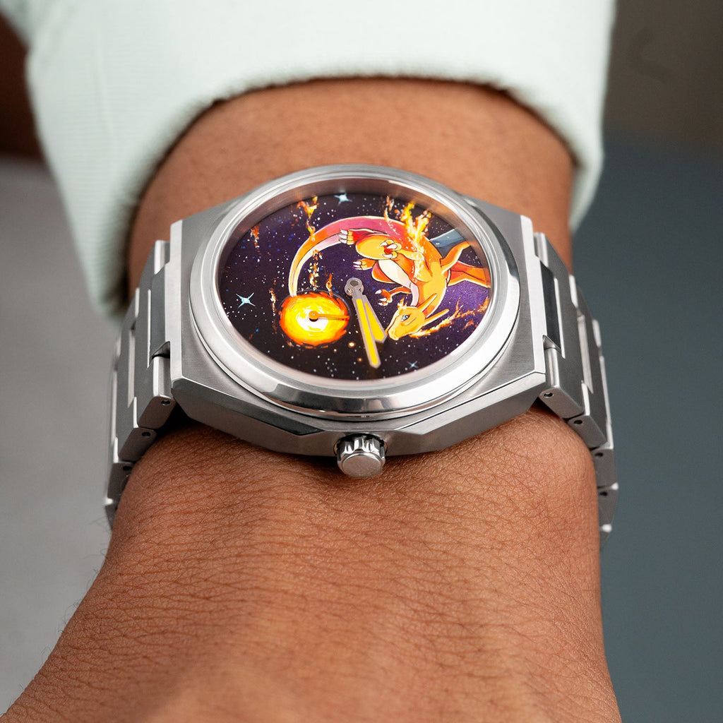 Defiant Inferno Concept held in hand — full view of the hand-painted fire-breathing icon with trailing flames on a cosmic black dial, 40.5mm Super Titanium™ automatic with hand-finished orange lume hands, a bespoke timepiece by IFL Watches.