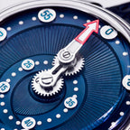 Mandetbrote Orbital Blue Kiss — Macro detail of the geared minute arm and red-tipped hand over the radiating dial texture, available at IFL Watches.