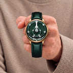 Mandetbrote Orbital Bronze Crush — Held in hand against a beige knit sweater, showing the folding minute arm, available at IFL Watches.