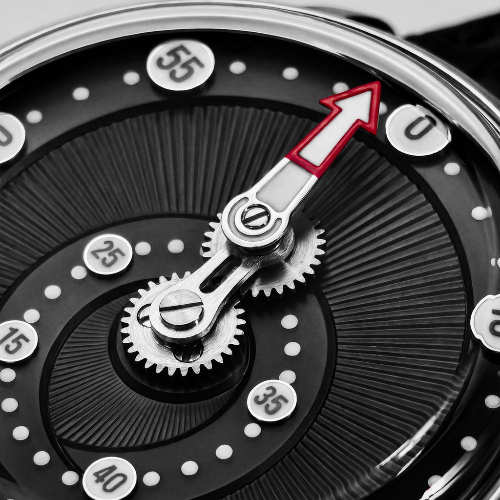 Mandetbrote Orbital Midnight Black — Macro detail of the geared minute arm and red-tipped hand over the radiating dial texture, available at IFL Watches.