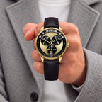 Mandetbrote Wandering Hour Gold — Held in hand against a grey coat, showing the hour discs and central seconds hand, available at IFL Watches.