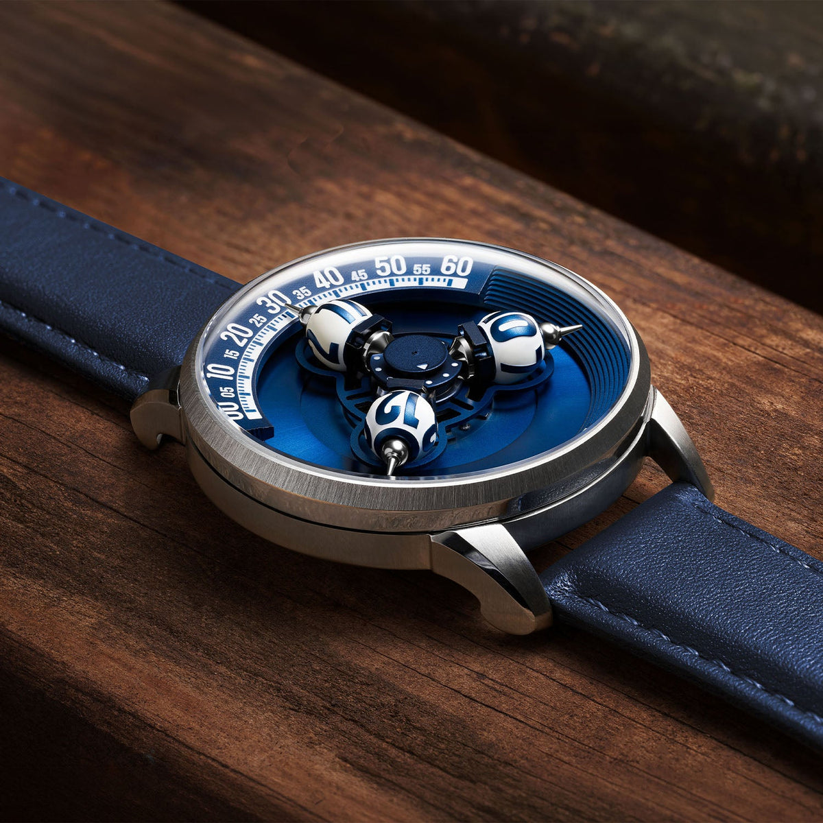 Vortichron Timeorb Blue — Low side view on wood, showing the case profile and raised spheres under sapphire crystal, available at IFL Watches.