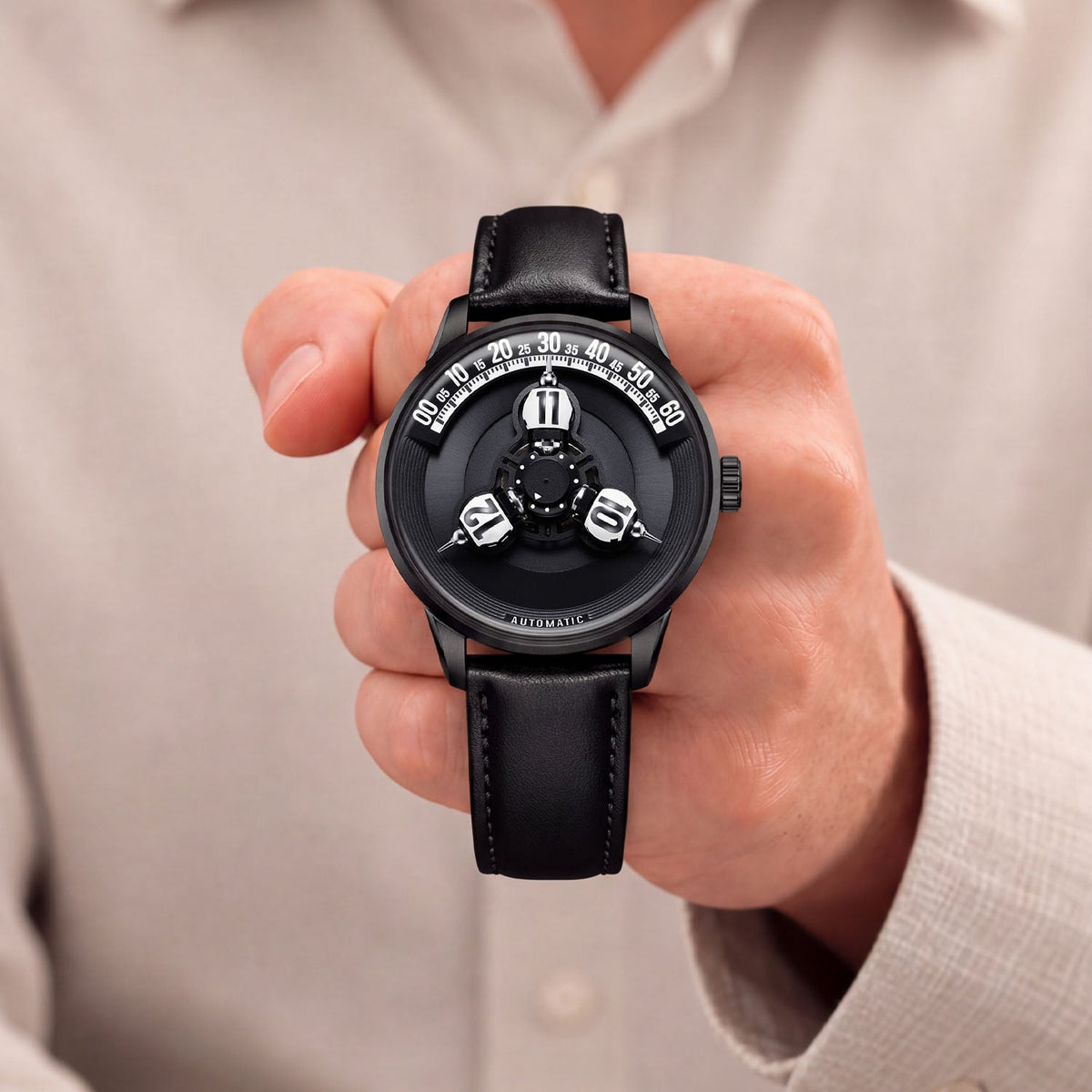 Vortichron Timeorb Midnight Black — Held in hand against a light shirt, showing the white numbered spheres on the dark dial, available at IFL Watches.